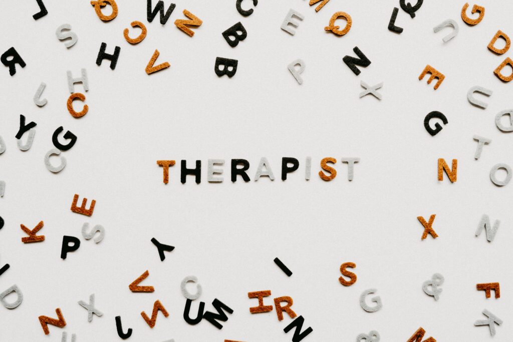 Close-up of letter blocks spelling therapist on a light background.