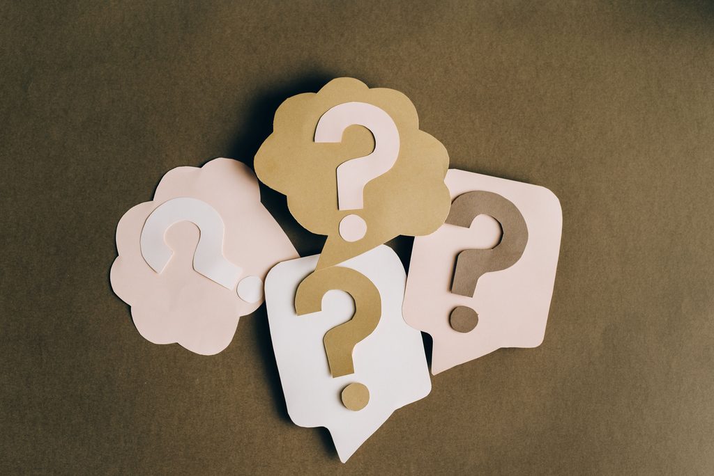 A graphic showing question marks next to papers, representing out-of-network costs and unknowns in mental health insurance.