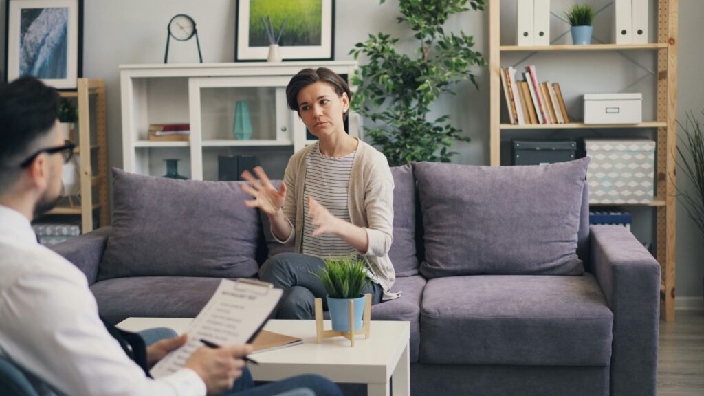 A lady sitting on a sofa and questions to ask her therapist.