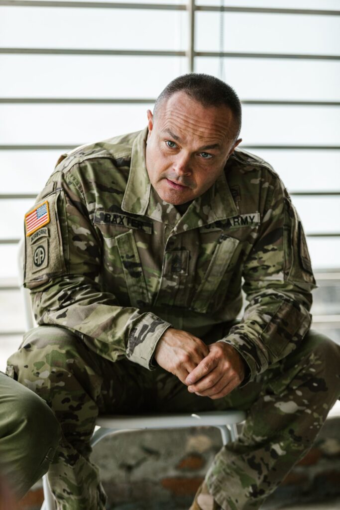 US Army veteran seated indoors, considering ADA workplace accommodations for PTSD