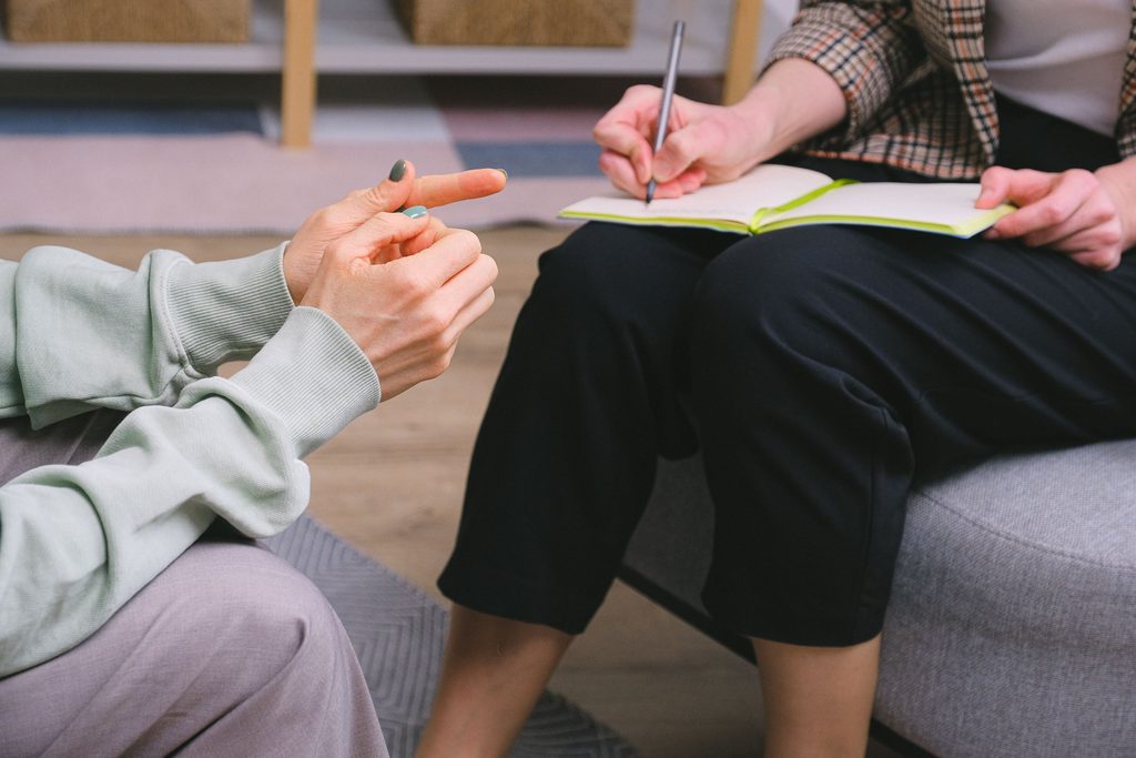 Clinician taking notes during a consultation for TMS therapy in McKinney, TX